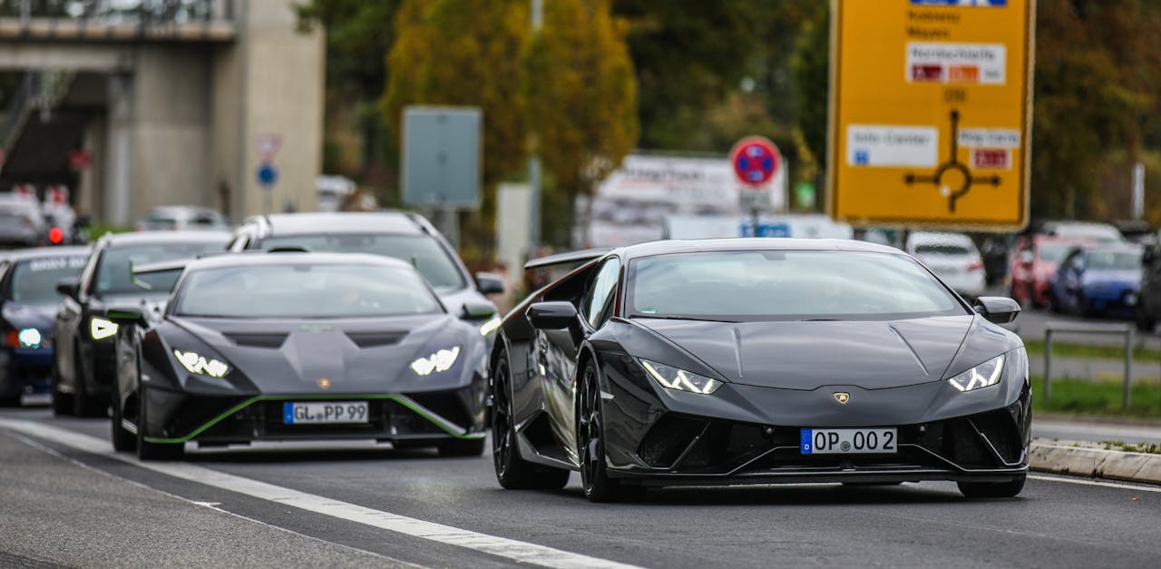 Black luxury sports cars driving on an urban road. Stylish and dynamic automotive scene.